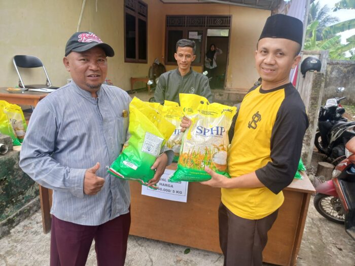 SIMBOLIS: Camat Warungkiara, Ali Muratdo saat menyerahkan beras yang dibeli masyarakat pada giat Gerakan Pasar Murah. FT: KARIMULLAH//INILAHSUKABUMI.COM
