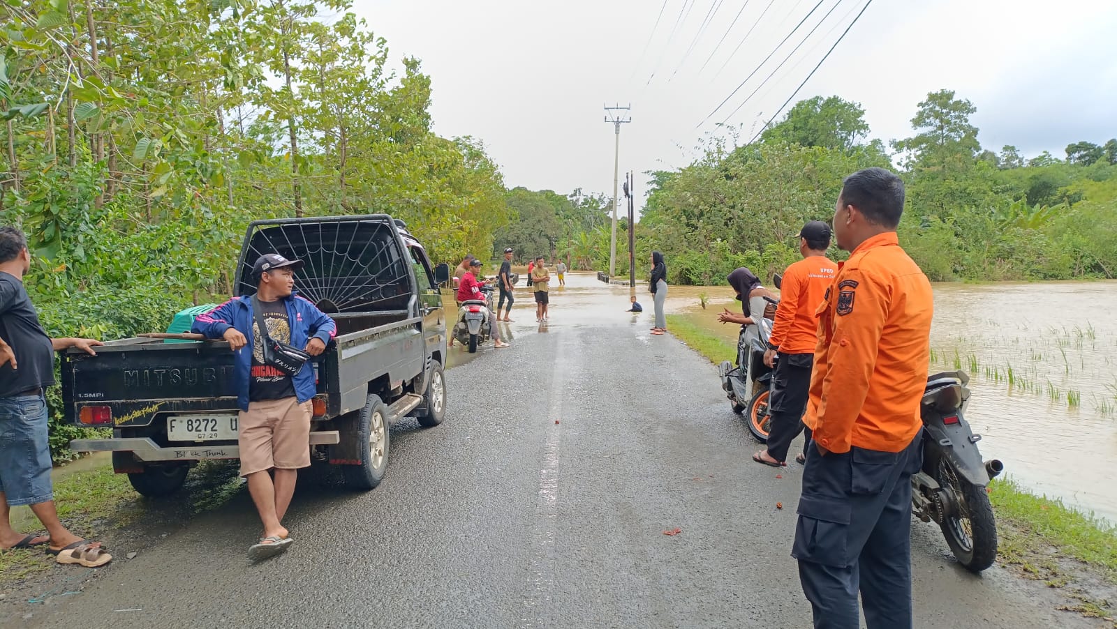 TERGANGGU: Petugas BPBD bersama warga memantau luapan Sungai Ciletuh yang merendam ruas jalan penghubung Desa Mekarsakti–Desa Mandrajaya, Kecamatan Ciemas, Kabupaten Sukabumi, Kamis (15/1/2026), sehingga akses kendaraan tidak dapat dilalui. Foto: Istimewa
