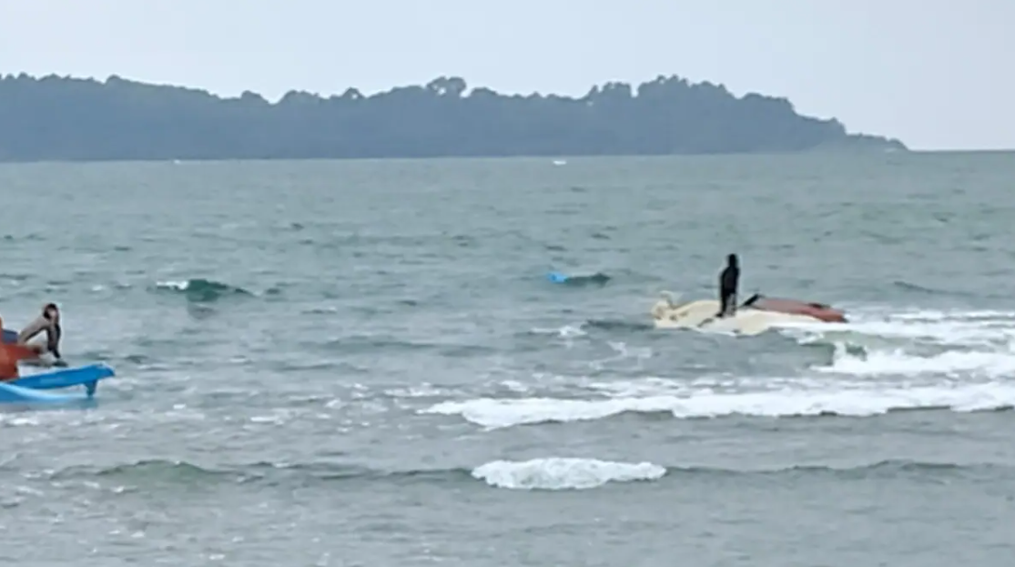 LAKALAUT: Perahu nelayan terbalik usai diterjang ombak di perairan Ujunggenteng, Kabupaten Sukabumi, Kamis (15/1/2026) sore. Nelayan berhasil diselamatkan oleh rekan sesama nelayan, sementara perahu dievakuasi ke daratan. Foto: Istimewa/Tangkapan Layar Wargaet