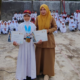 MEMBANGGAKAN: Ayko Mikhaila Arifin, siswa SDN Karangtengah, Kecamatan Cibadak, Kabupaten Sukabumi, menunjukkan medali dan piagam Juara 1 Bupati Cup didampingi wali kelasnya usai upacara di sekolah. Foto: Idam//INILAHSUKABUMI.COM