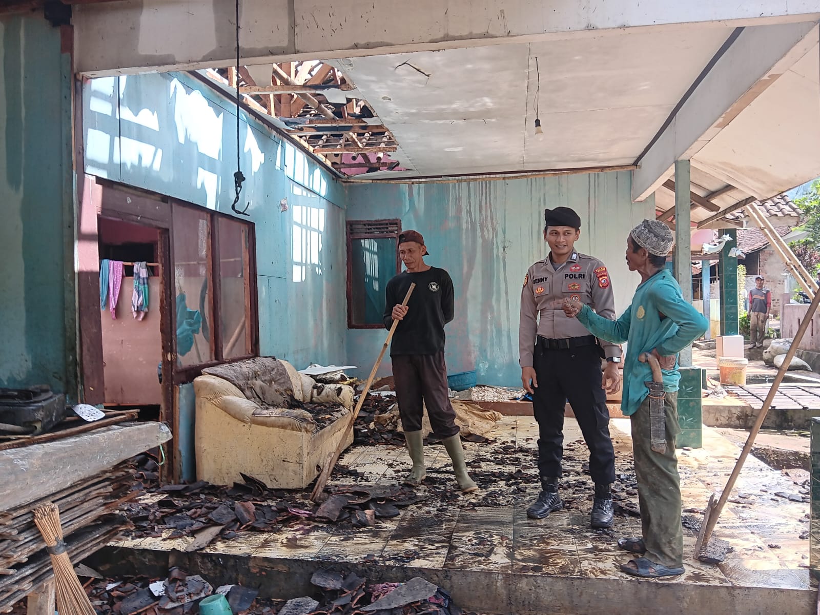 MENENANGKAN: Seorang anggota Polsek Cikembar menenangkan warga yang rumahnya terbakar di Kampung Citengah RT 07 RW 02, Desa Sukamulya, Kecamatan Cikembar sekira pukul 08.00 WIB. FT: KARIMULLAH//INILAHSUKABUMI.COM
